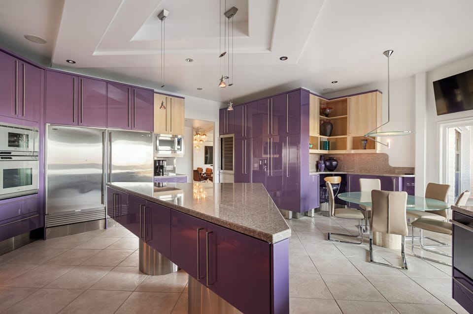 Designer kitchen showcases bold custom cabinetry, premium stainless appliances, expansive prep surfaces, and sleek contemporary finishes.