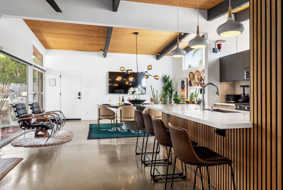 Gather around this stunning kitchen island where sleek design meets warm wood accents, creating your perfect space for morning coffee and evening conversations.