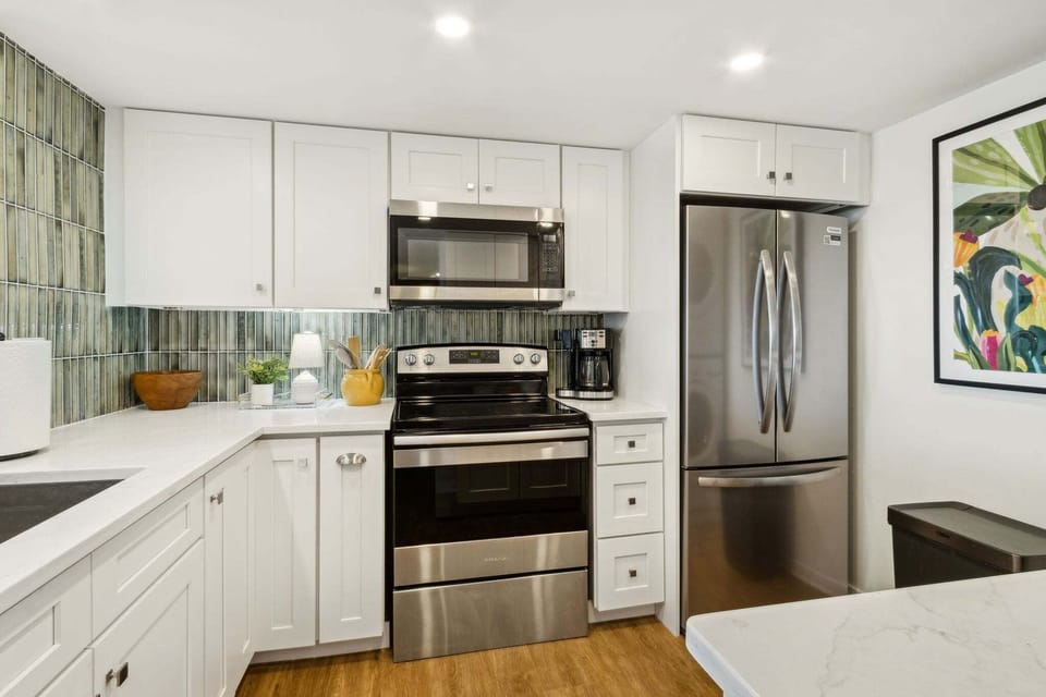 Newly Updated Kitchen with Quartz Countertops, Stainless Steel Appliances, and Stylish Tiled Backsplash