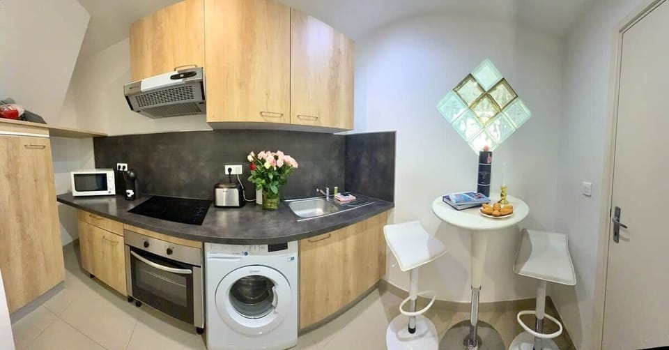 Cuisine entièrement équipée avec four, plaques, machine à laver et tout le nécessaire pour cuisiner.