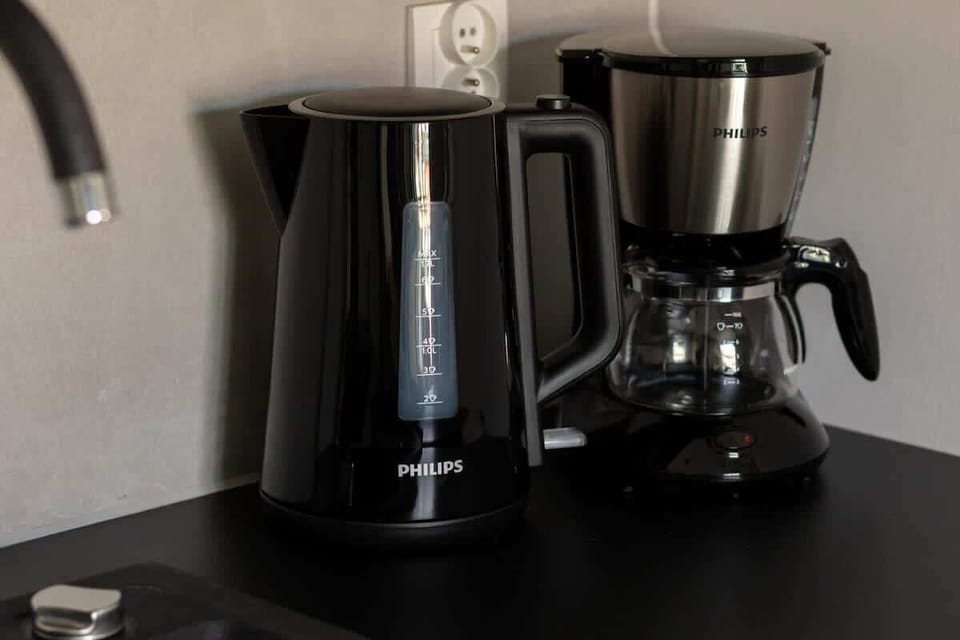 Coffee and espresso machines placed on a sleek black countertop.

