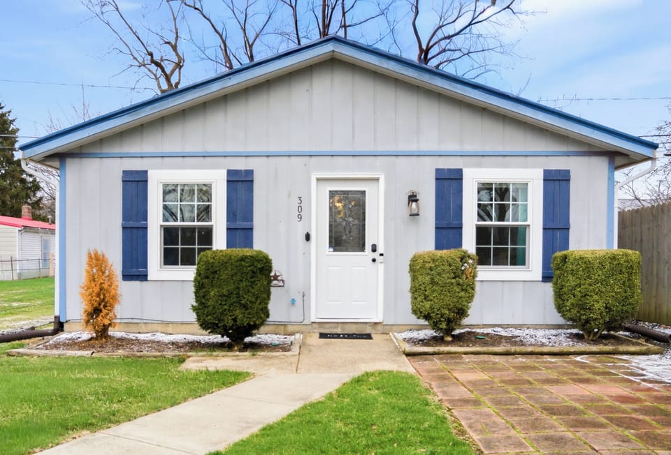 Partially fenced front yard, patio with a grill and seating