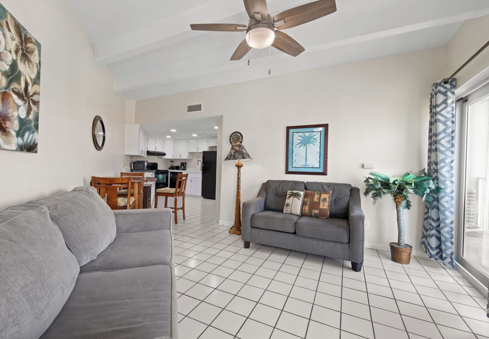 Spacious living area with vaulted ceilings and an open layout leading into the dining area and kitchen