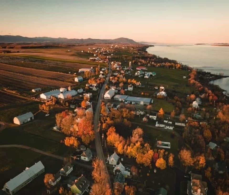 Vue aérienne : un décor de maisons accueillantes et de panoramas à couper le souffle pour une escapade inoubliable. Entre fleuve et montagnes, laissez-vous charmer par la beauté paisible de la région.