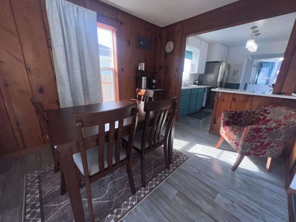 Your cozy loft retreat features rich wood details and a charming staircase leading to your private sleeping space, with natural light streaming through the windows to brighten your home away from home.