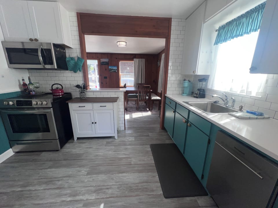 Your stylish kitchen blends coastal vibes with modern convenience—sleek cabinetry, stainless appliances, and a serene color palette make meal prep a pleasure.