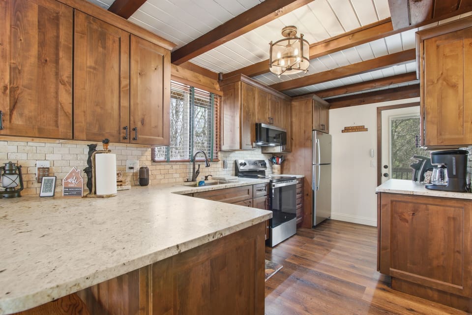 Fully equipped kitchen — stainless appliances + warm wood cabinetry