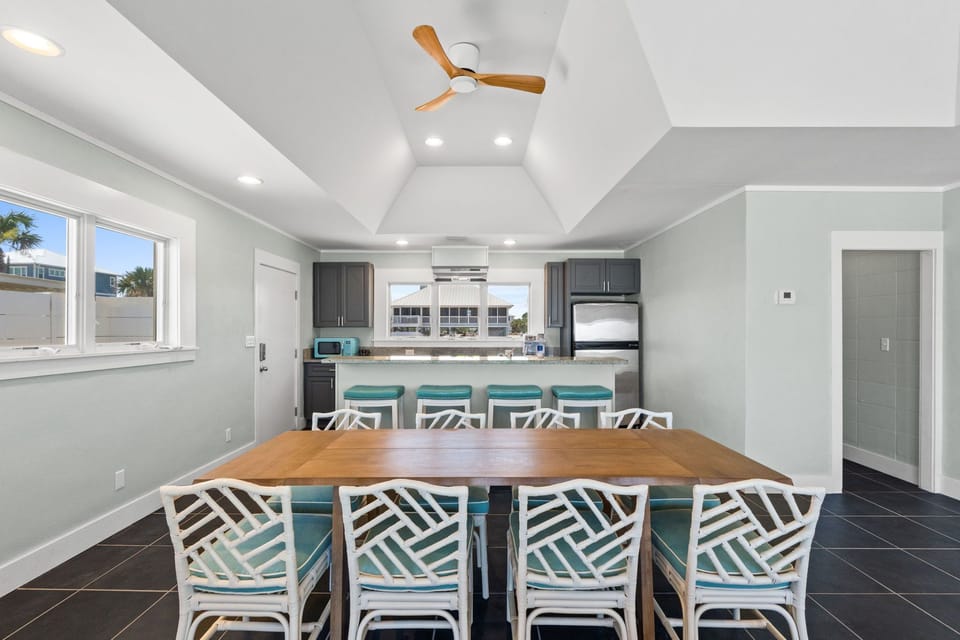 Gather around the spacious dining table where your group can share meals together, while the modern kitchen with breakfast bar seating creates the perfect space for cooking and conversation.