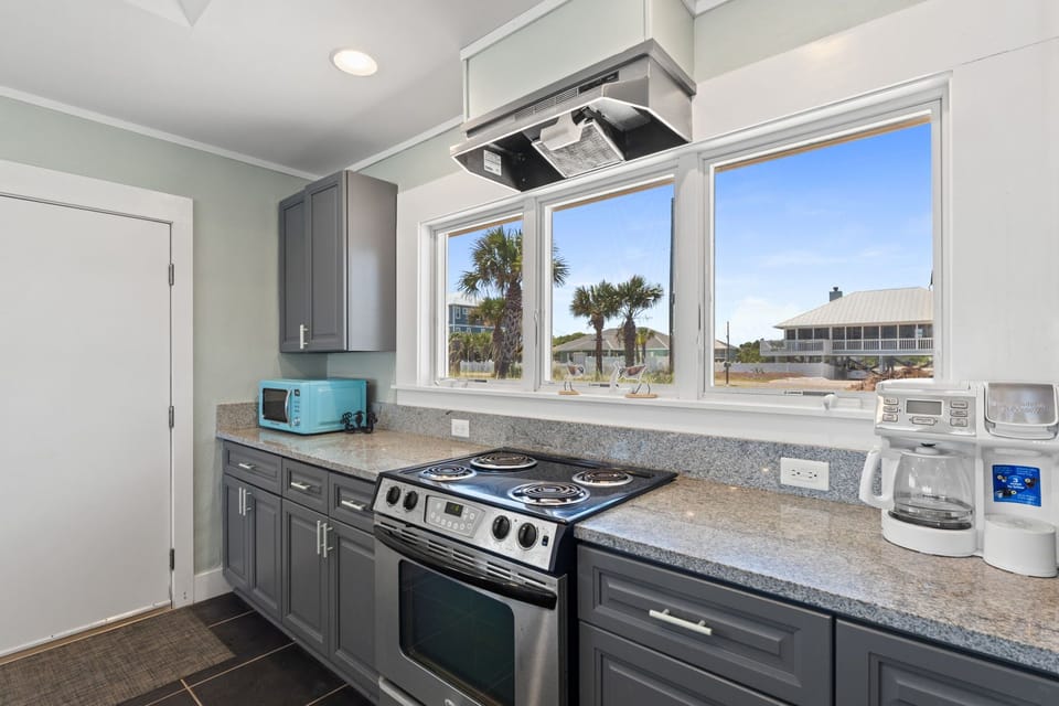 Your coastal kitchen is designed for easy meal prep with a stove, microwave, and coffee maker. Enjoy views of swaying palm trees and beachside charm through the large windows.