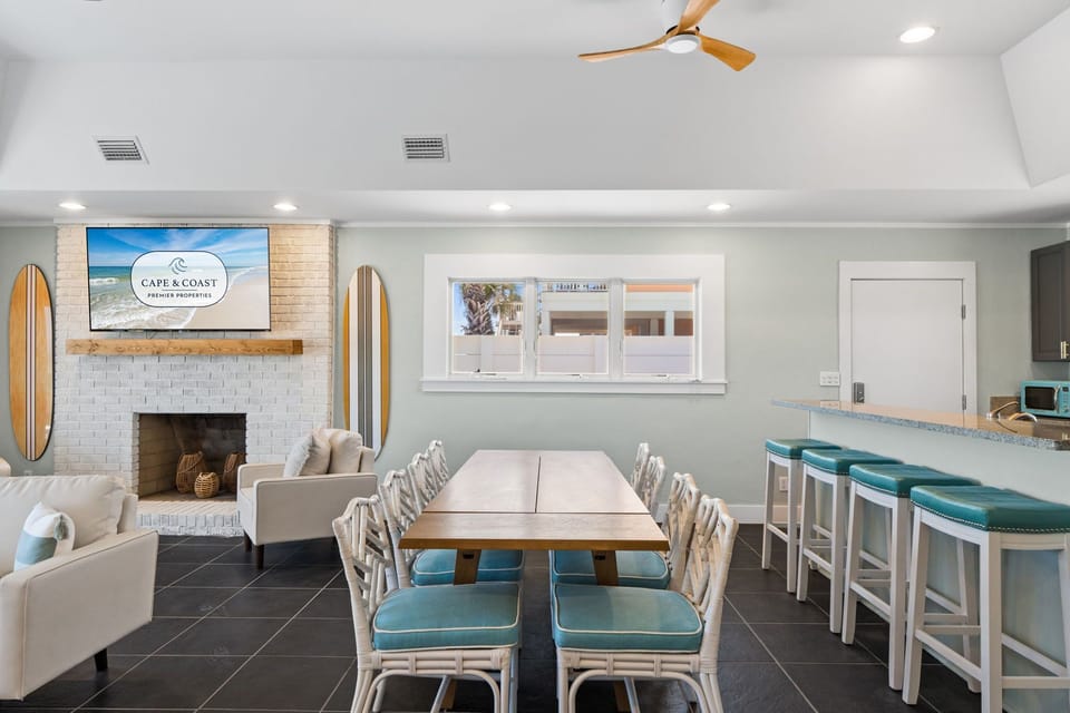 This coastal-inspired communal lounge invites you to gather with friends around the dining table or relax by the fireplace, with surfboard décor and a bar for socializing.