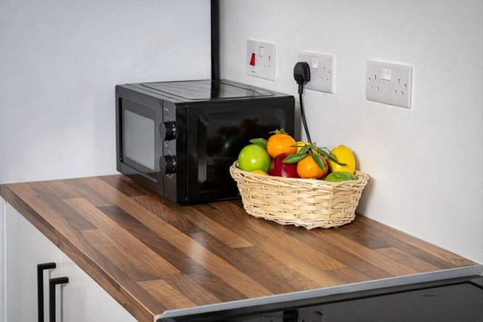 Kitchen counter with a microwave and a fruit bowl.