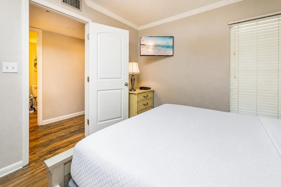 Experience comfort in this cozy guest bedroom, enjoying a good movie after a day at the beach