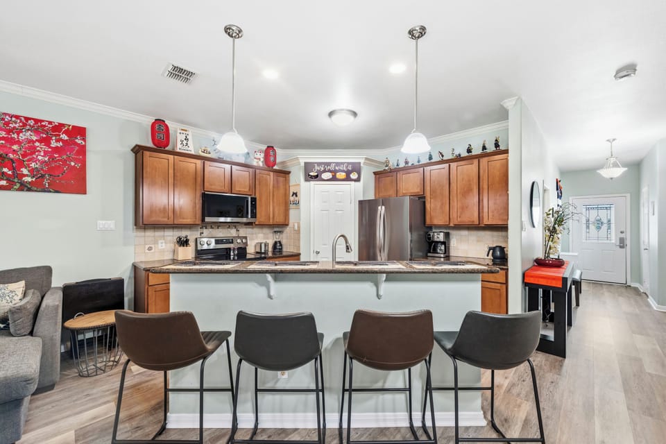 Gather around the spacious kitchen island, perfectly designed for morning coffee or evening meals. Modern appliances, warm wood cabinetry, and thoughtful touches make this your home away from home.