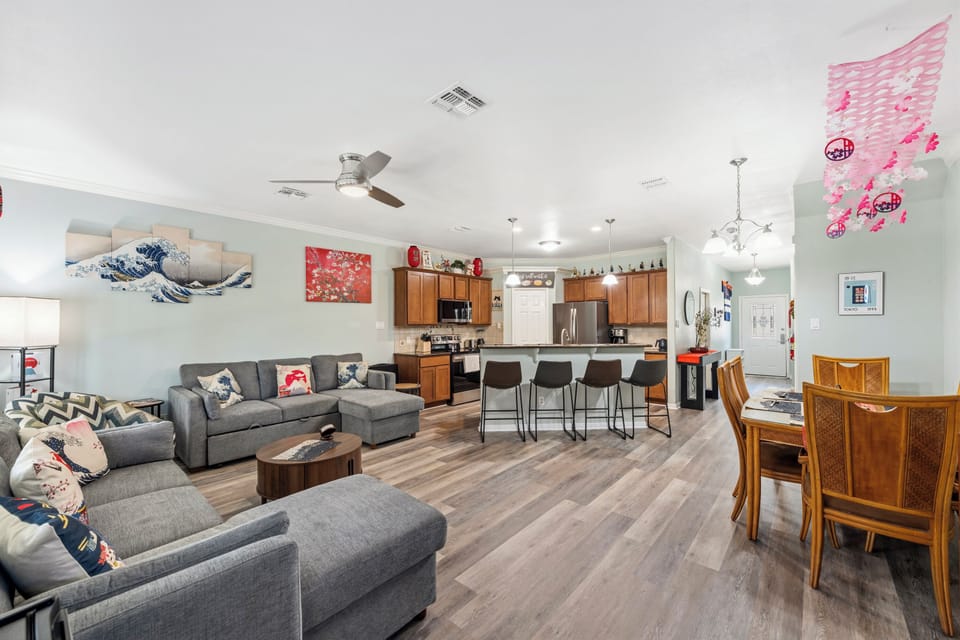 Unwind on plush sofas in your spacious open-concept living area, where the kitchen's breakfast bar invites morning coffee and the dining table seats your crew for memorable meals together.