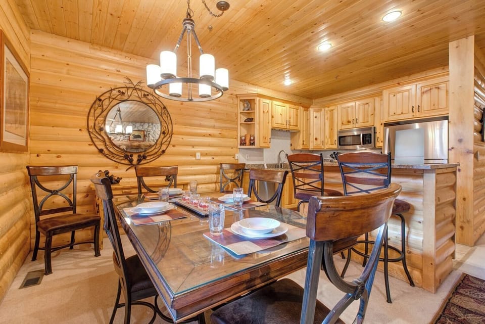 Dining table for six with rustic wood finishes and mountain-inspired lighting for cozy meals in.
