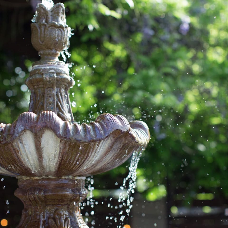 Stone fountain and garden path at the Healing Gardens Massage & Spa, located on-site.