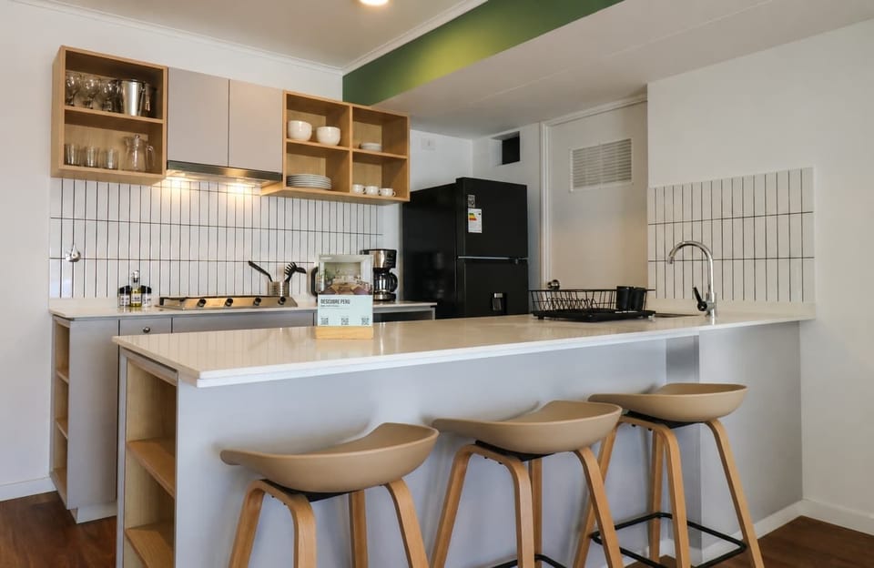 Fully equipped open kitchen with breakfast bar and stools