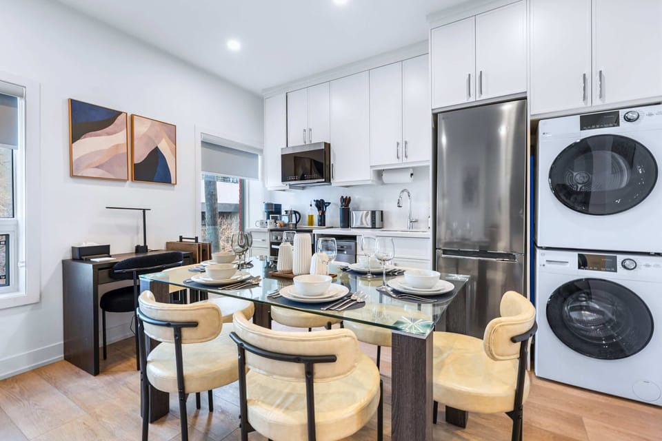 Modern dining area set for four beside the fully equipped kitchen.