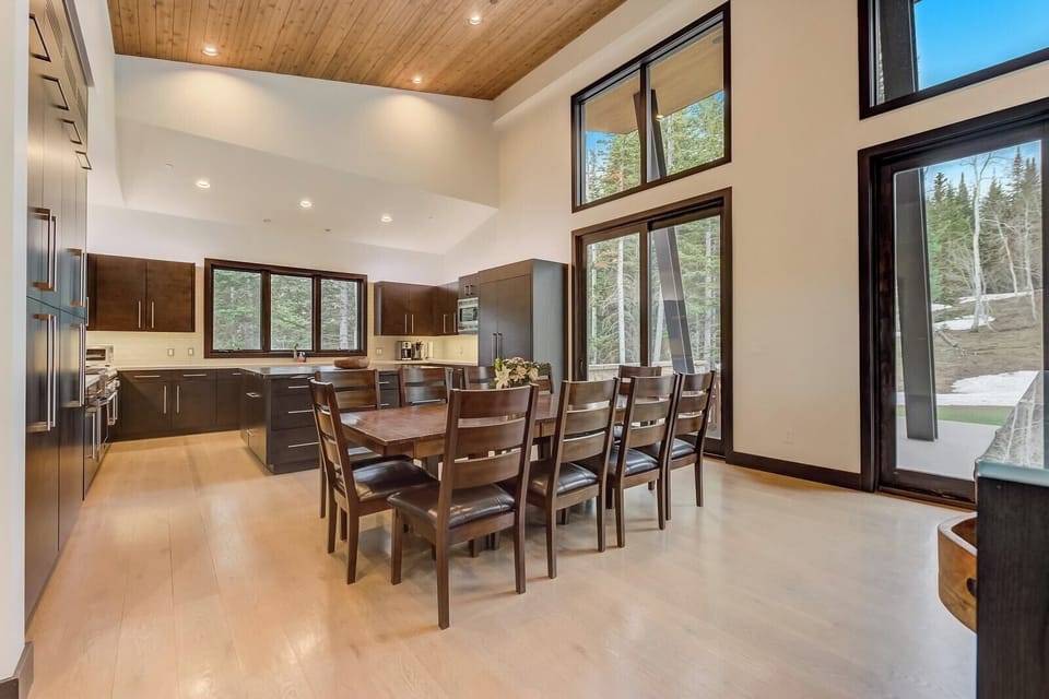 Dining table for 10 sits beneath vaulted ceilings and glowing pendant lights.