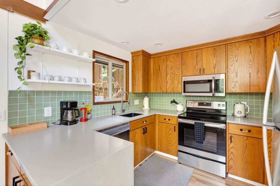 Kitchen with stainless appliances and green tile.