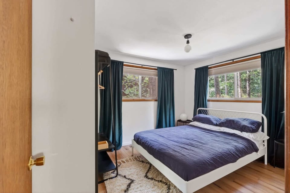 Bedroom 2 with queen bed and forest views.