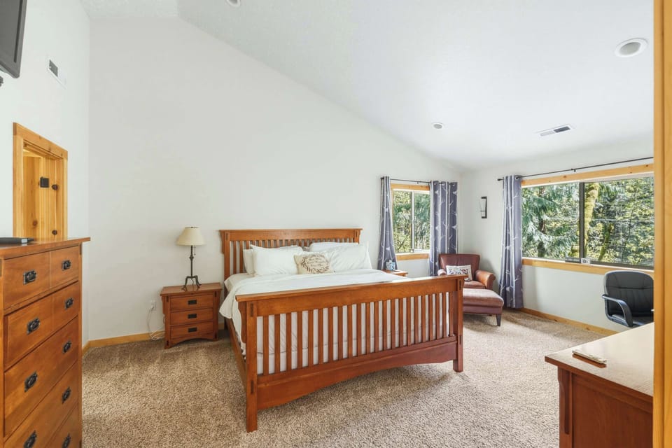Bedroom with wooden bed frame, dresser and desk.
