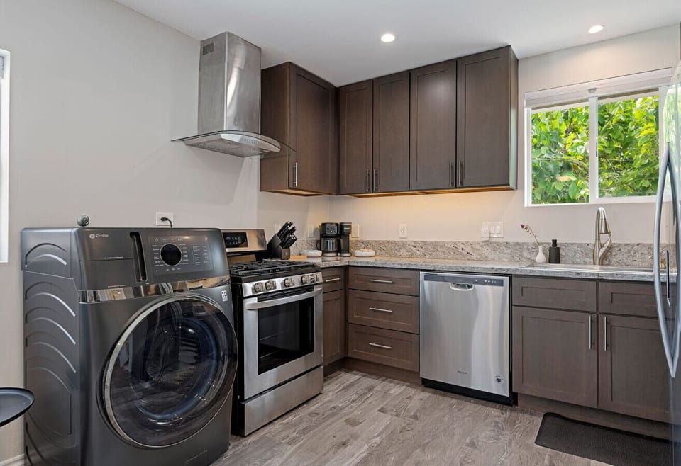 Fully equipped kitchen with stainless appliances and in-unit all in one washer/dryer