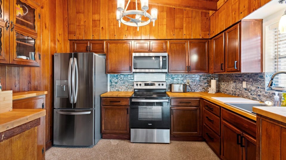 The rustic kitchen is well equipped with cooking essentials, coffee maker, oven, stove, full size refrigerator and freezer, microwave, and toaster.