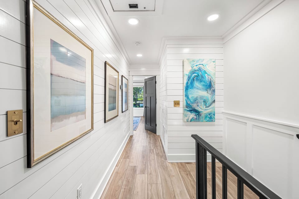 Upstairs hallway. You can walk through this space to reach the different bedrooms and enjoy the clean, coastal decor.