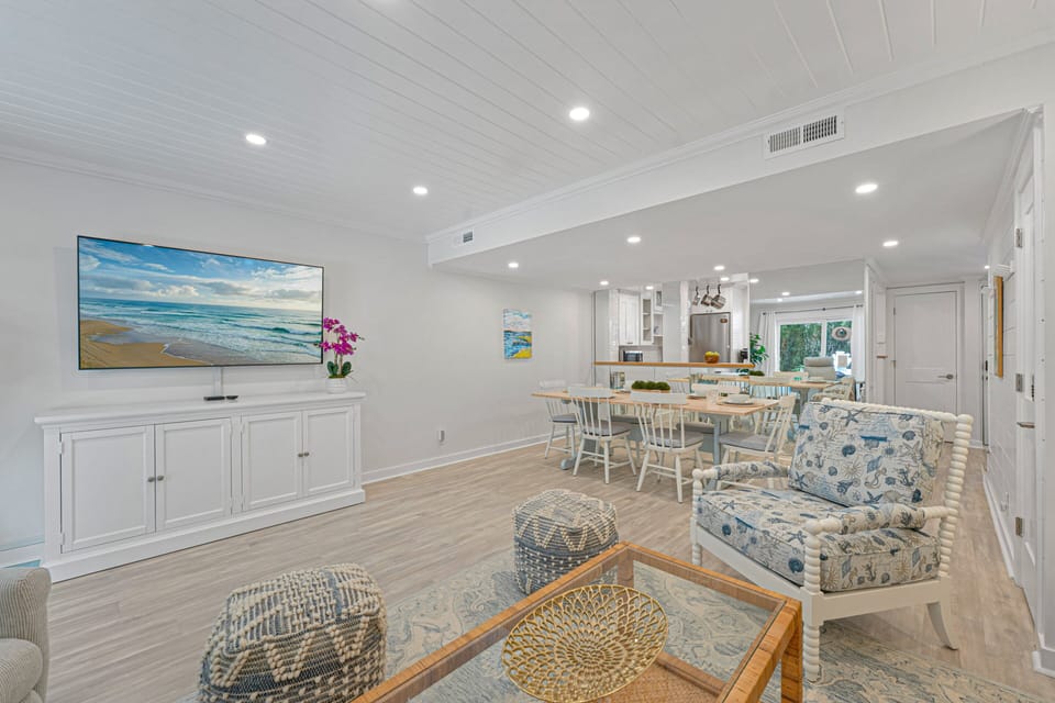 Spacious main living area with a bright coastal design, large gathering spaces, and seamless connection to the dining area and kitchen.