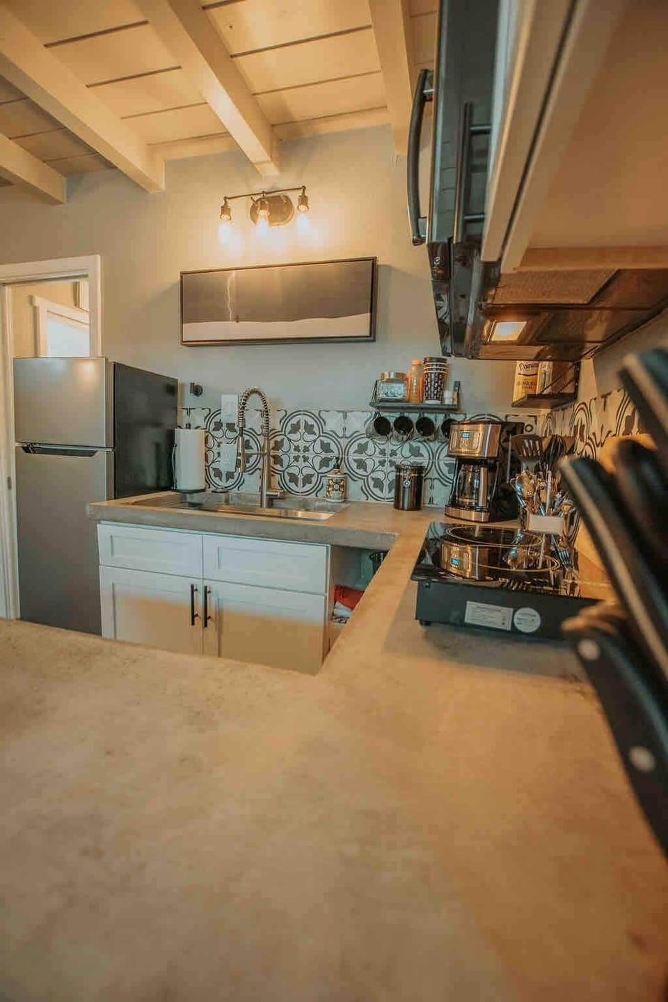 Custom concrete countertops in a well appointed area for you to enjoy everything from coffee to a home-cooked meal! (*Please note: no oven in this unit.)
