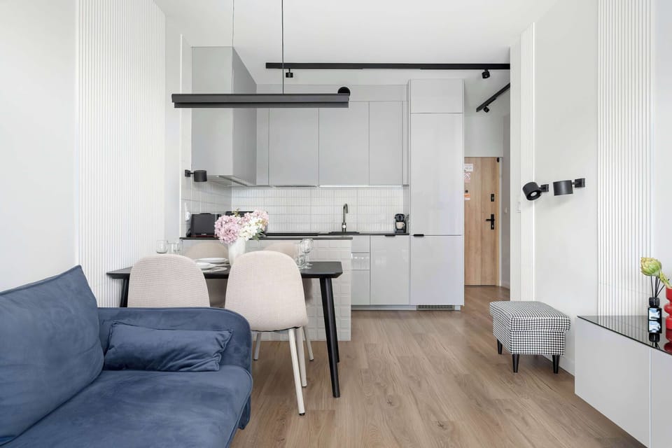 An open-plan perspective from the living area looking across the room towards the kitchenette.