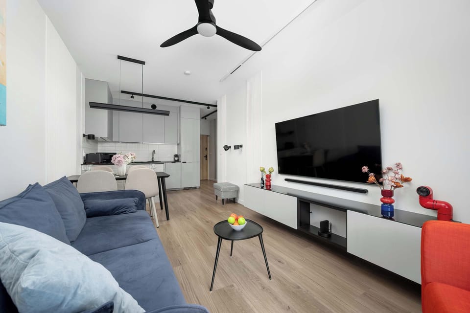 A wider shot of the living and dining space showing the layout with the kitchen tucked into the far background.