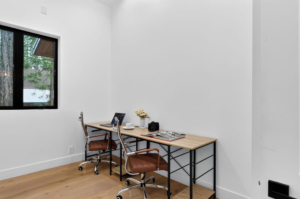 Dedicated workspace with two desks, comfortable chairs, and a window for natural light.