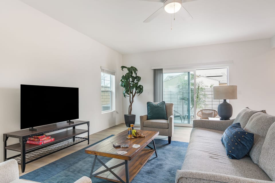 Welcome to your spacious, sun-filled living room featuring sleek wood-style flooring.