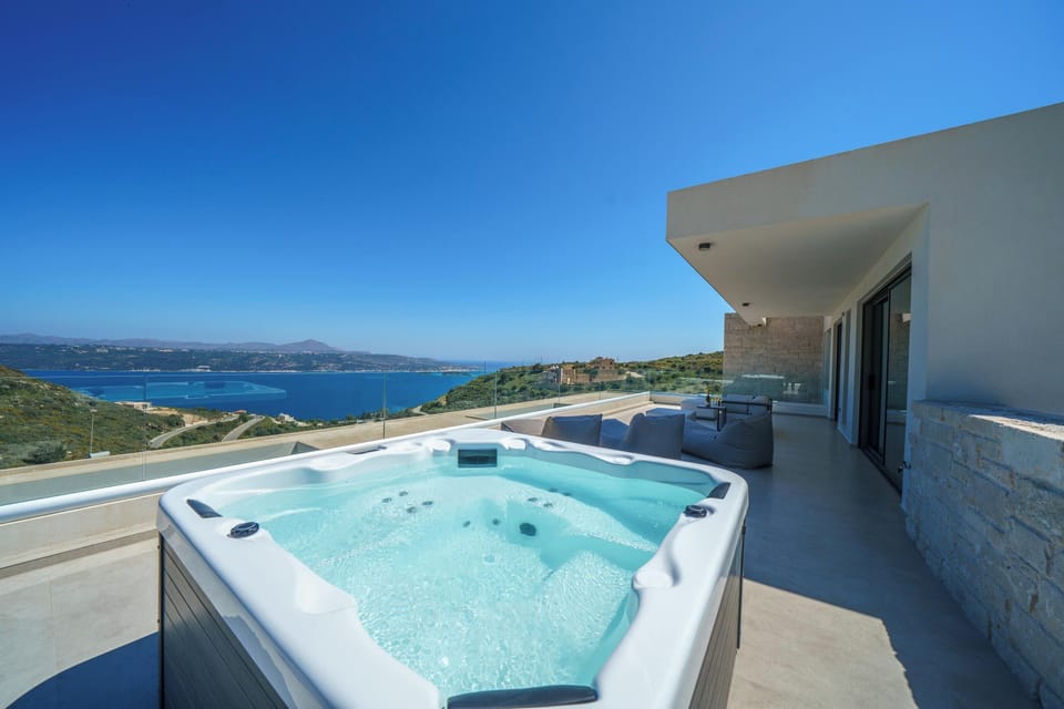 A spacious shared balcony featuring a relaxing five-seat jacuzzi and uninterrupted sea views