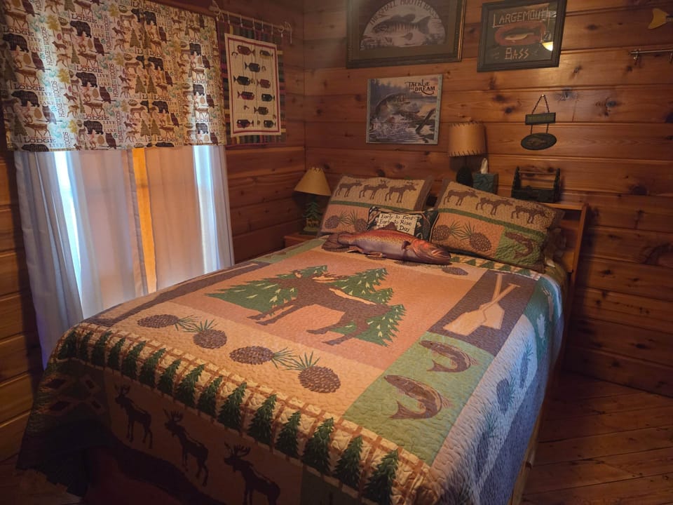 The fishing full bedroom is decorated for anglers with a small TV with roku