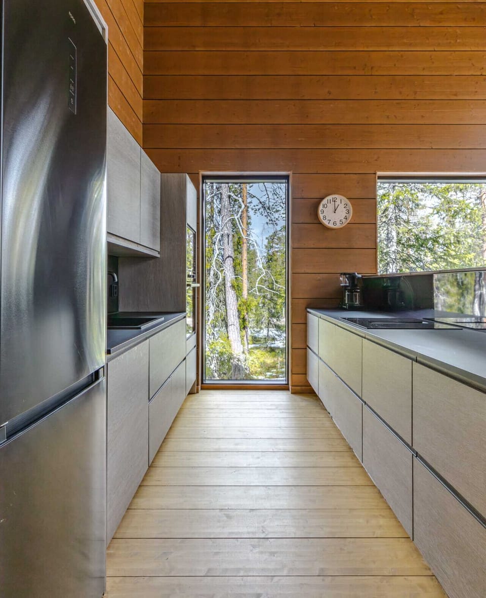 Brew your morning coffee with a view of the Lapland wilderness through the floor-to-ceiling kitchen window. The sleek, handleless cabinetry provides ample storage for all your groceries during a long-term stay.