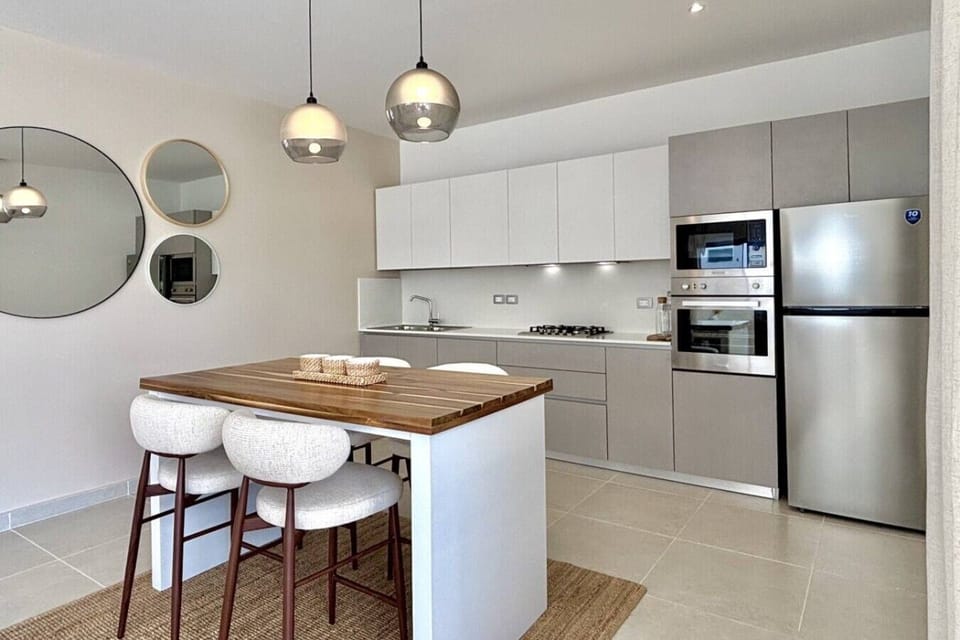 Fully equipped modern kitchen with full-size appliances, cookware, and a dining island—great for quick breakfasts or meals at home during your stay.