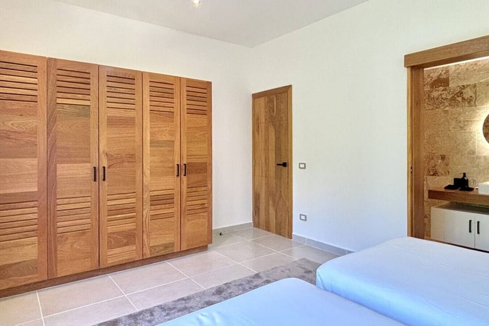 Bedroom 2 offers flexible sleeping arrangements with twin beds, built-in wardrobe storage, and direct access to the ensuite bathroom.