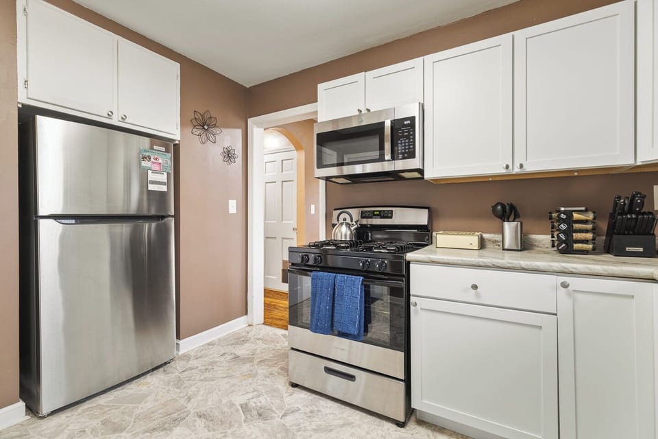 Bright kitchen with stainless appliances, gas range & coffee setup