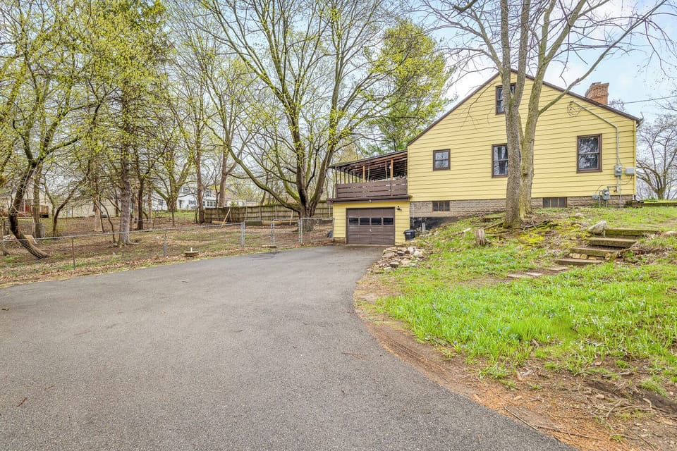 Private wooded yard with deck, fenced area, ample parking, and garage.