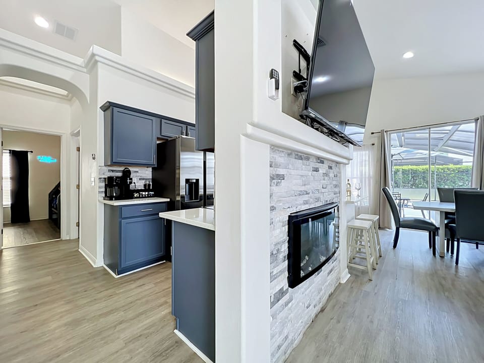 Modern fireplace feature connecting the kitchen and family room areas beautifully.