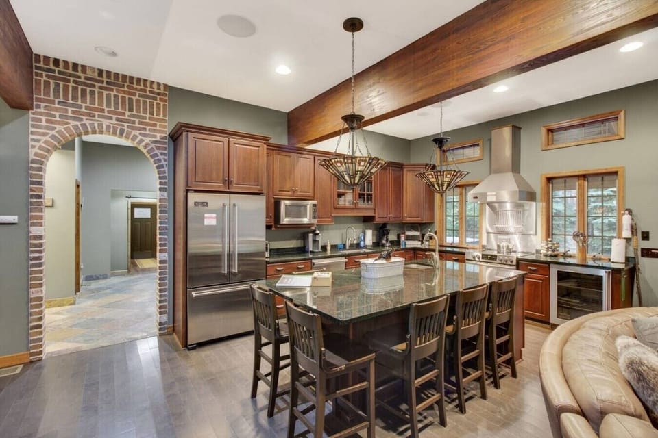 Full kitchen with a granite island and bar seating — set up for cooking for a crowd.