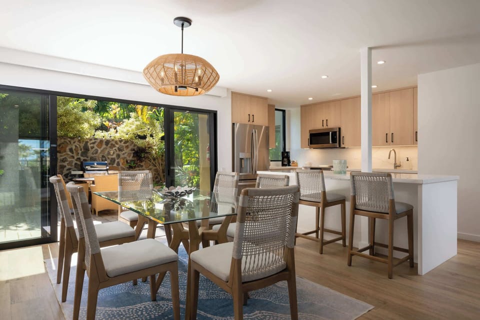 Seating for six at the glass dining table plus three more at the kitchen bar — built for hosting family dinners and beach-day lunches.