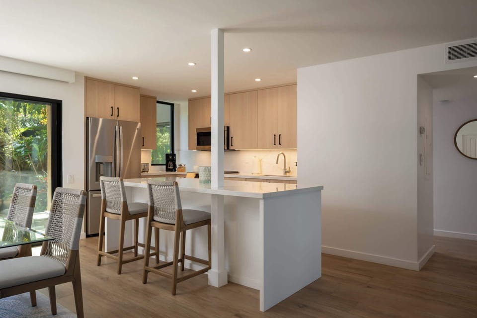 The waterfall-edge island anchors the kitchen and seats two at the breakfast bar — the perfect perch for morning papaya and Hawaiian sun.