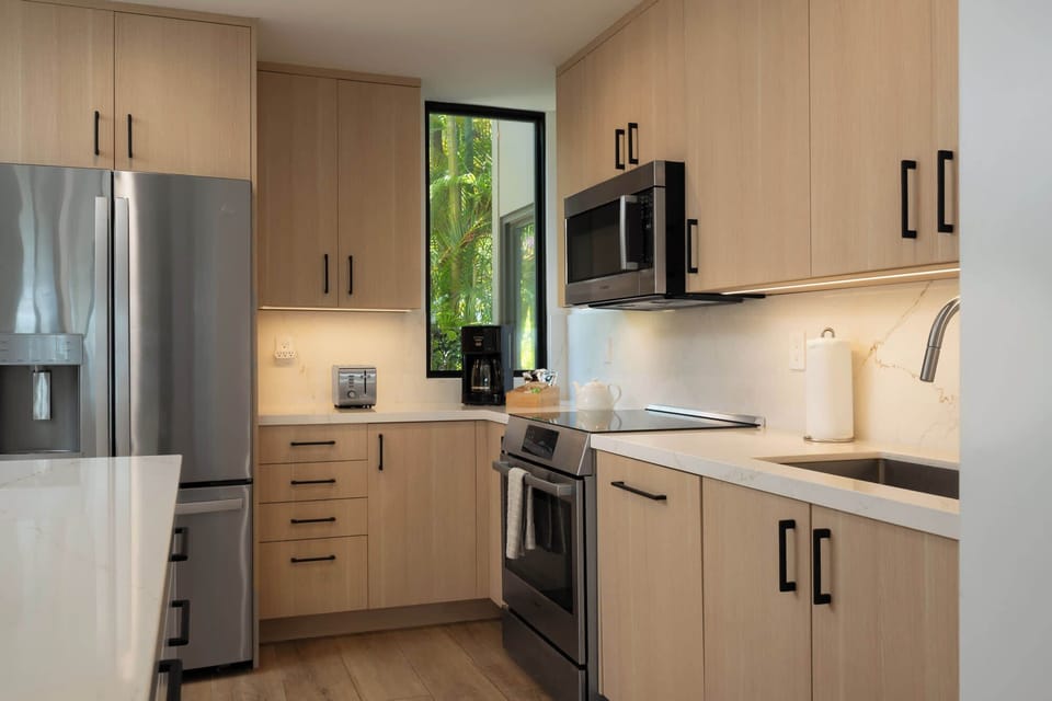 Fully renovated chef's kitchen with Bosch stainless appliances, quartz counters, soft-close white-oak cabinetry, and a coffee station ready to go.