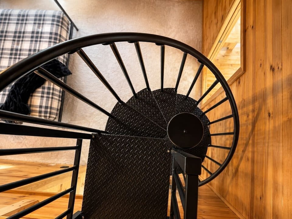 A stylish spiral ascent leading to your private lofted sanctuary in the master suite.