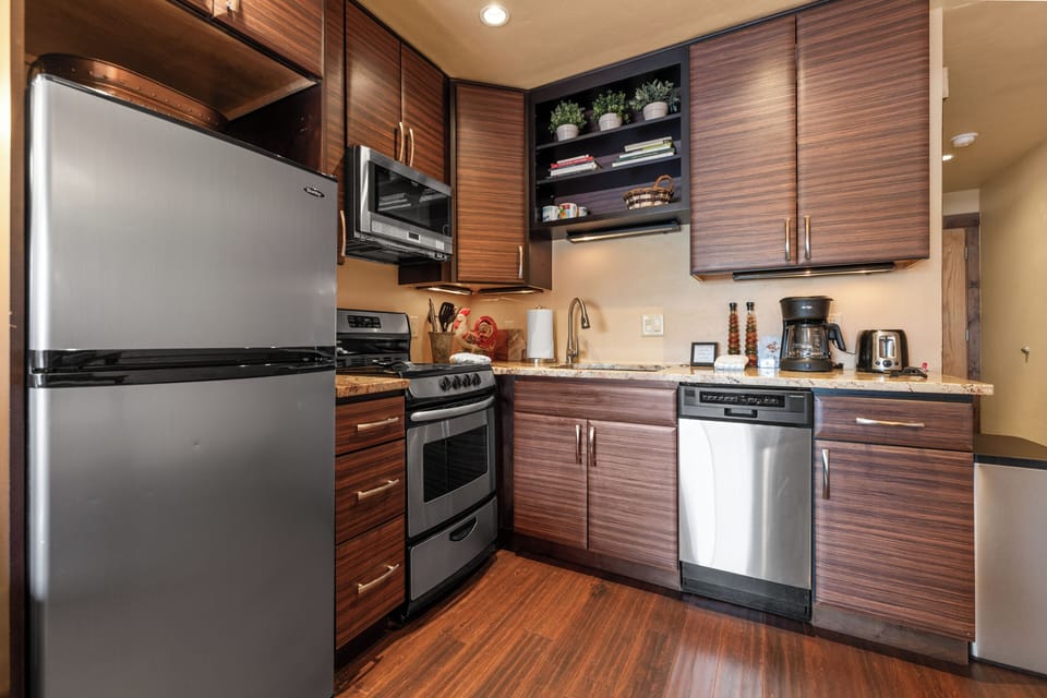 Your stylish kitchen features rich wood cabinetry, granite counters, and stainless appliances—perfect for whipping up meals or enjoying morning coffee in your home away from home.