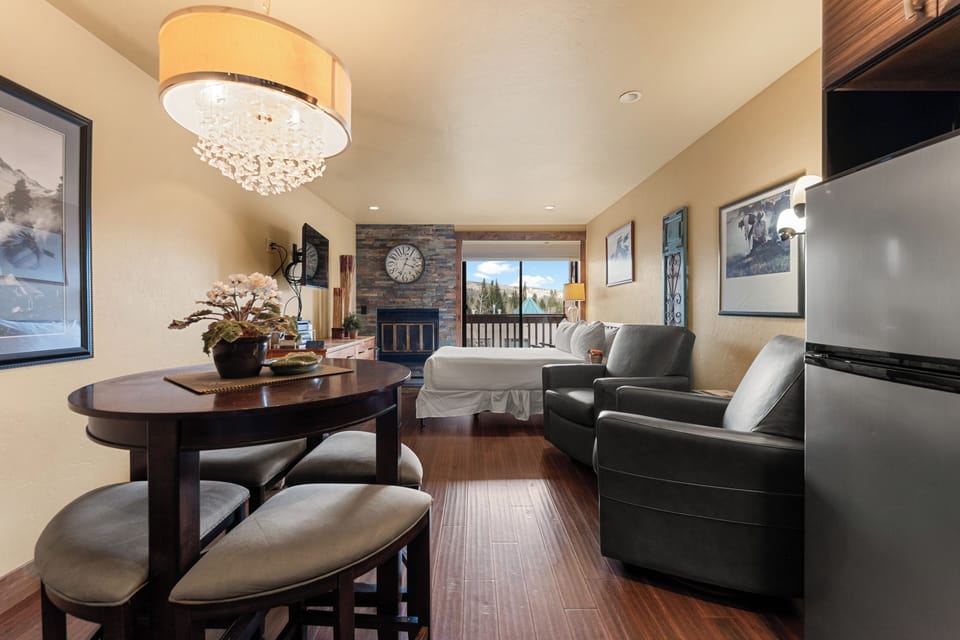 Relax in your inviting living space with a cozy fireplace, elegant chandelier lighting, and stunning mountain views framing your getaway.
